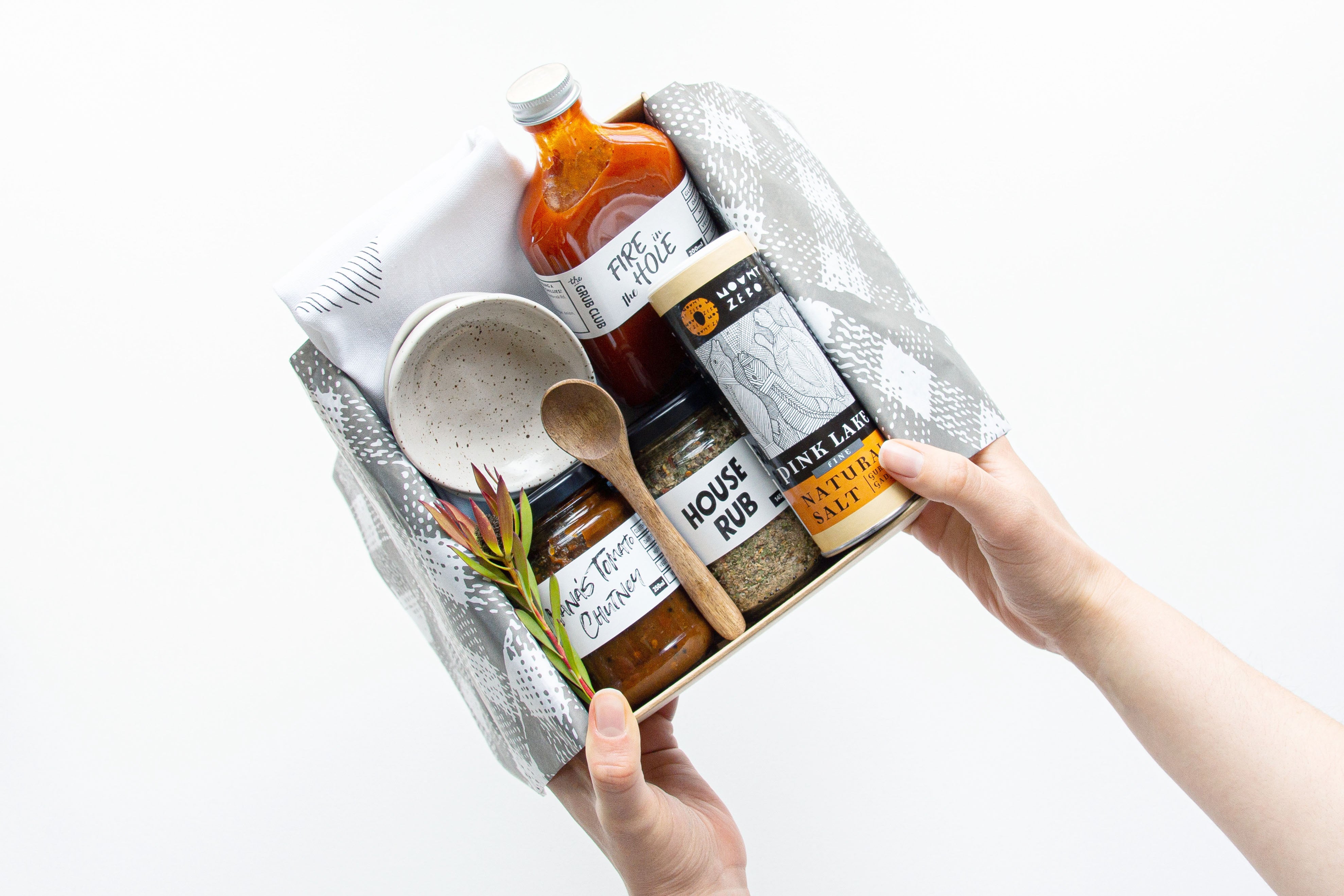 Person holding a gift box with sustainable kitchen products for a Bindle gift hamper on a white background