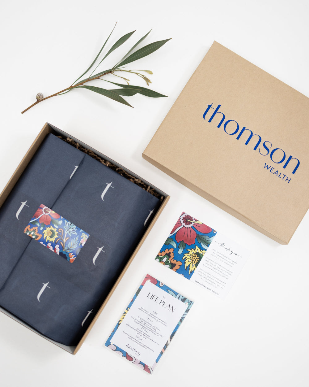 Custom-branded corporate gift hampers with Thomson Wealth logo and sustainable packaging
