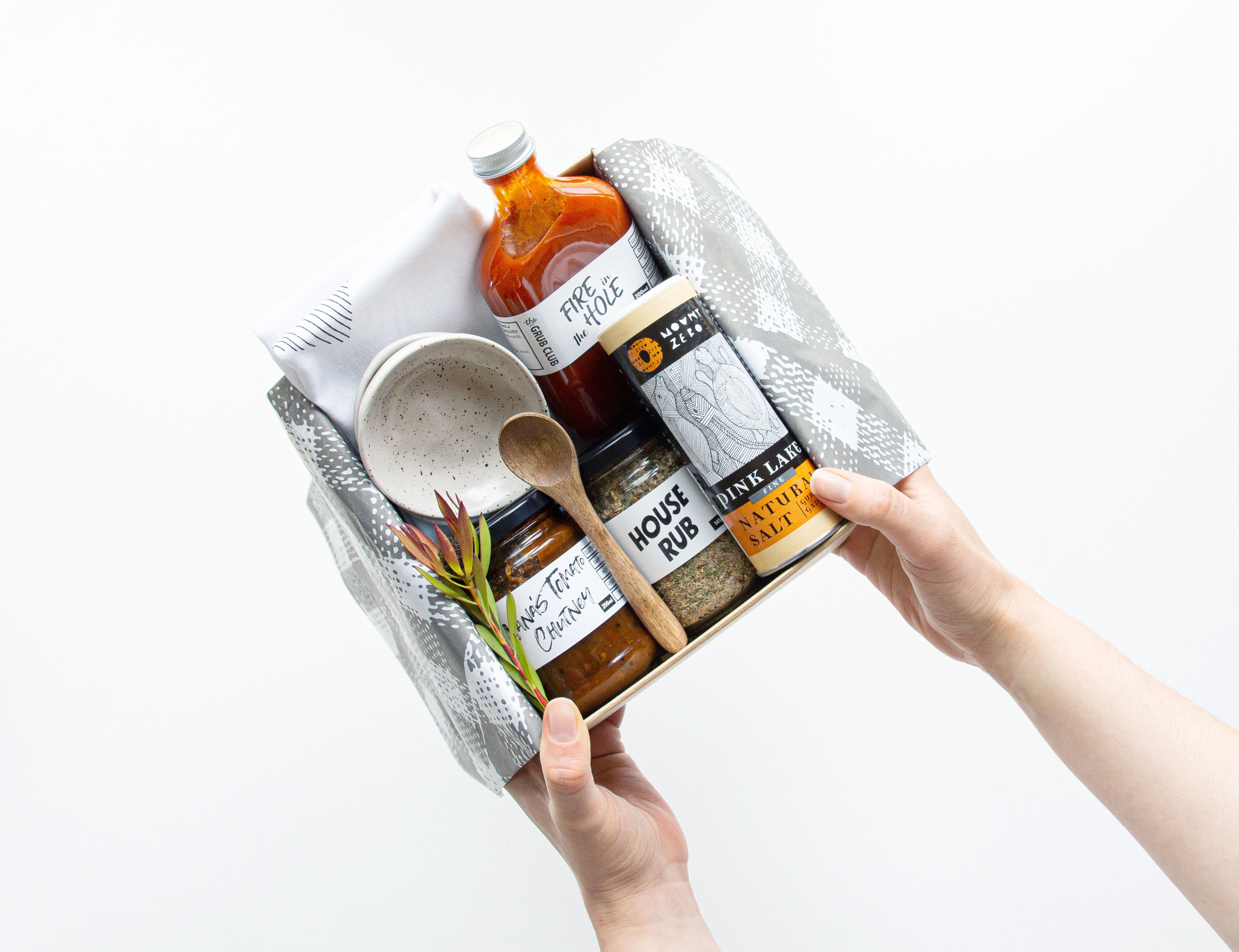 Person holding a gift box with sustainable kitchen products for a Bindle gift hamper on a white background